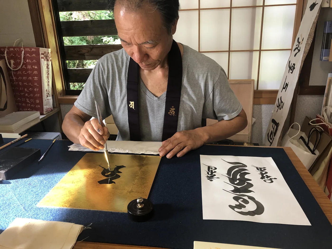 金地の作品に筆を入れる田邊武